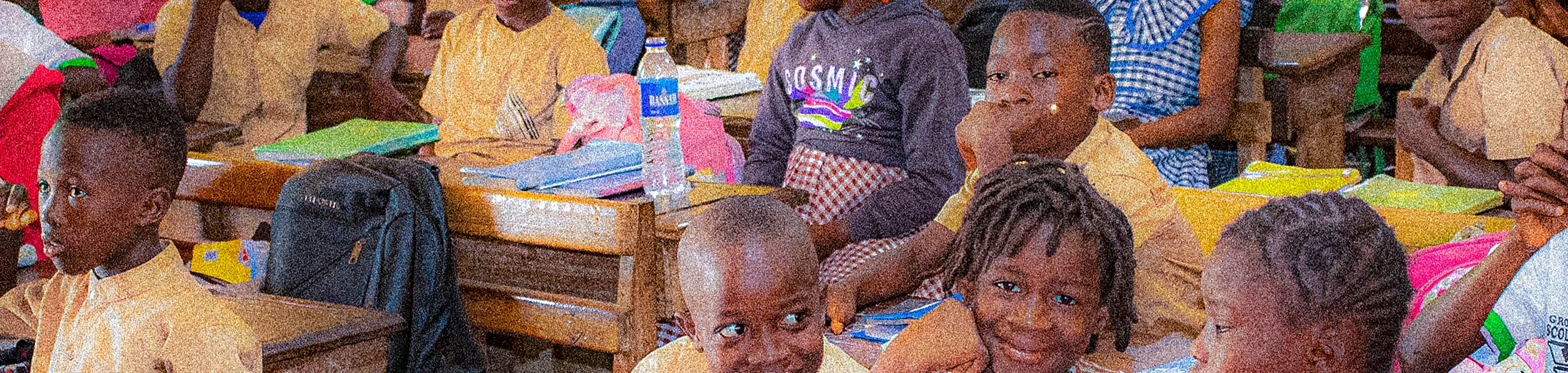 Élèves souriants à leurs pupitres dans une classe de Bouaké